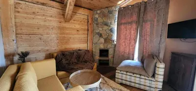 a living room with a couch and chairs and a fireplace at Chalets-Appartements Tourtite in Ifrane