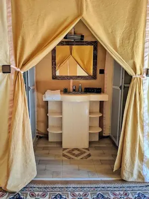 a bathroom with a sink and a mirror at Merzouga Luxury Dunes Camp in Merzouga