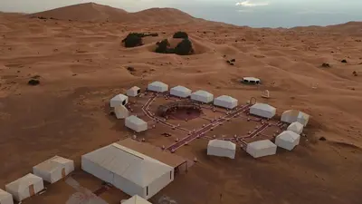 an aerial view of a desert with a group of buildings at Merzouga Luxury Dunes Camp in Merzouga