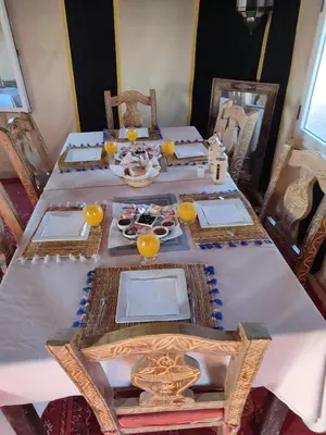 a dining room table with a white table cloth at Merzouga Luxury Dunes Camp in Merzouga