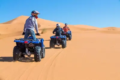 three people riding on atvs in the desert at Diament Luxury Camp-Sahara Desert Experience in Merzouga in Merzouga