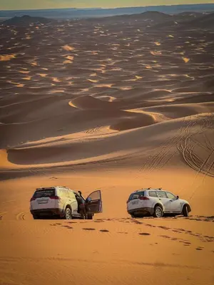 two cars parked in the sand in the desert at Diament Luxury Camp-Sahara Desert Experience in Merzouga in Merzouga