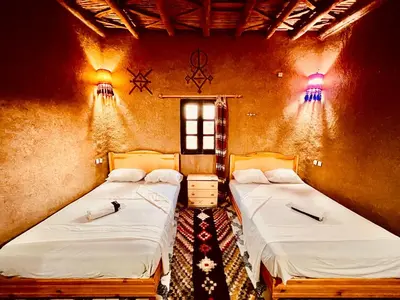 a room with two beds in a room at Hotel Camping Les Roses Des Dunes & Piscine in Merzouga