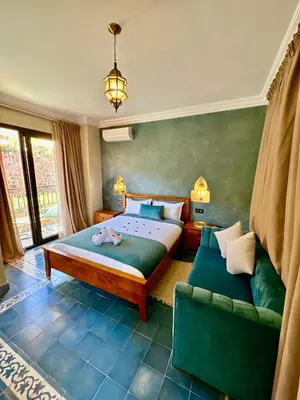 a bedroom with a large bed and a couch at Riad Timskrine in Ourika