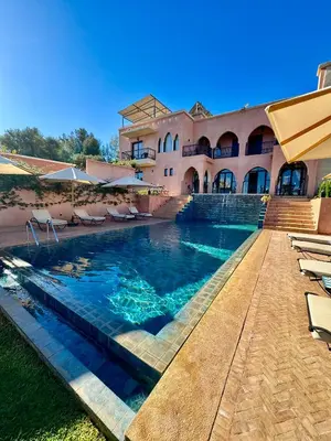 a swimming pool in front of a house at Riad Timskrine in Ourika