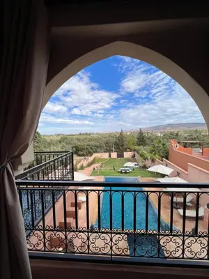 a room with a view of a pool from a balcony at Riad Timskrine in Ourika