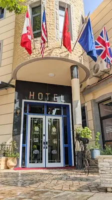 a hotel with flags in front of a building at Hôtel La Chambotte in Imouzzer Kandar
