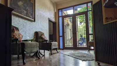 a living room with a glass table and chairs at Hôtel La Chambotte in Imouzzer Kandar