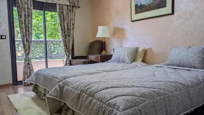 a bedroom with two beds and a window at Hôtel La Chambotte in Imouzzer Kandar
