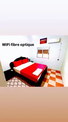 a bedroom with a red bed in a room at Cozy Host House with 2 air conditioned rooms in Er Rachidia