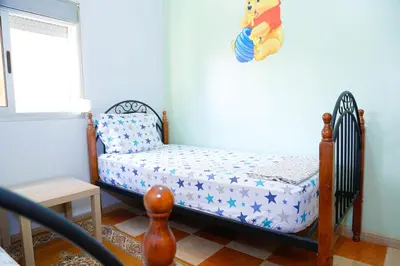 a small childs bed in a room with a window at Cozy Host House with 2 air conditioned rooms in Er Rachidia