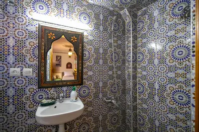 a bathroom with a sink and a mirror at Riad Fes Allouch in Fès