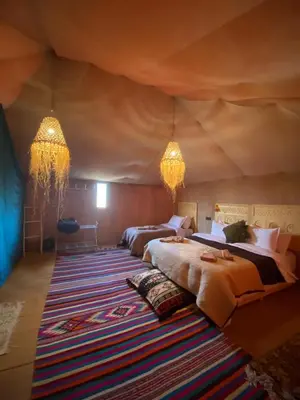 a bedroom with two beds in a tent at lecherif luxury Camps in Merzouga