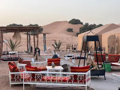 a group of chairs and tables in the desert at lecherif luxury Camps in Merzouga
