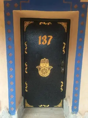 a black door with the number on it at Hotel le Touareg in Merzouga