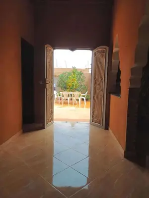 an open door leading to a patio with a table at Luxury apartment Hassilabied Merzouga in Hassilabied