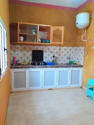 a kitchen with white cabinets and a tiled floor at Luxury apartment Hassilabied Merzouga in Hassilabied