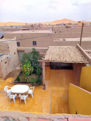 a view of a patio with a table and chairs at Luxury apartment Hassilabied Merzouga in Hassilabied