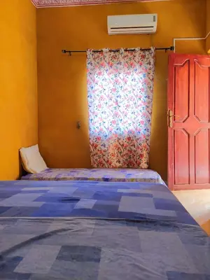 a bedroom with a bed with a curtain and a window at Luxury apartment Hassilabied Merzouga in Hassilabied
