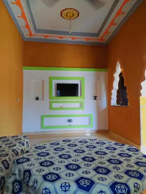 a bedroom with a bed and a tv on the wall at Luxury apartment Hassilabied Merzouga in Hassilabied