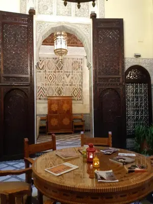 a dining room with a wooden table and chairs at Riad Fes Palacete in Fès