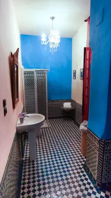a blue bathroom with a sink and a toilet at Riad Fes Palacete in Fès