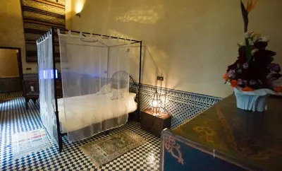 a room with a shower and a table with a lamp at Riad Fes Palacete in Fès