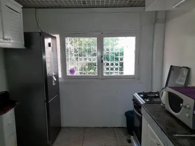 a kitchen with a refrigerator and a window at superbe appartement bien placé in Fès