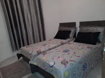 a bed with a comforter with planets on it at superbe appartement bien placé in Fès