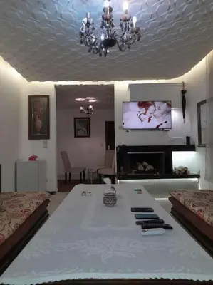 a living room with a table and a tv at superbe appartement bien placé in Fès