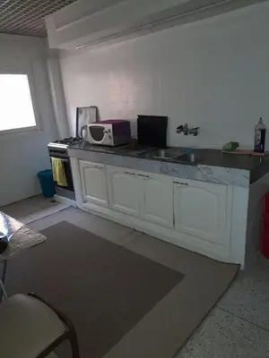 a kitchen with a counter with a sink and a microwave at superbe appartement bien placé in Fès