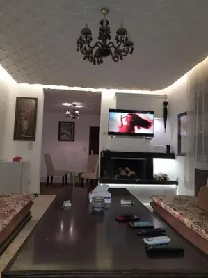 a living room with a table and a tv at superbe appartement bien placé in Fès
