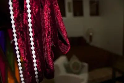 a red scarf with white beads hanging in a room at Collier De La Colombe in Meknès