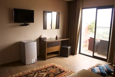 a living room with a television on the wall and a desk at Collier De La Colombe in Meknès