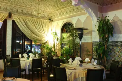 a dining room with tables and chairs and a ceiling at Collier De La Colombe in Meknès