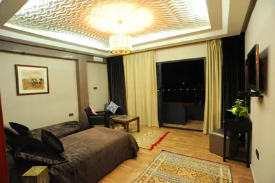 a bedroom with a bed and a living room at Collier De La Colombe in Meknès