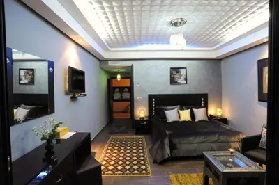 a bedroom with a bed and a living room at Collier De La Colombe in Meknès