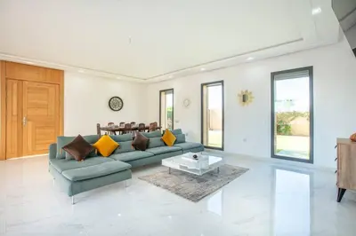 a living room with a couch and a table at Villa Sakina, piscine Chauffée, ping-pong, cuisinière in Marrakech