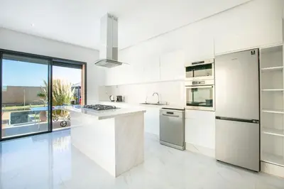 a kitchen with white appliances and a large window at Villa Sakina, piscine Chauffée, ping-pong, cuisinière in Marrakech