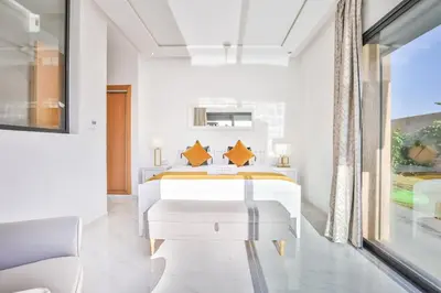 a white bedroom with a bed and a window at Villa Sakina, piscine Chauffée, ping-pong, cuisinière in Marrakech