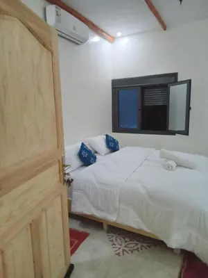 a bedroom with a bed and a tv and a door at Hotel AZUL Todra Gorges in Tinerhir