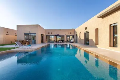 a swimming pool in front of a house at Villa Kassia , Jacuzzi, Hamman, jeux… in Marrakech