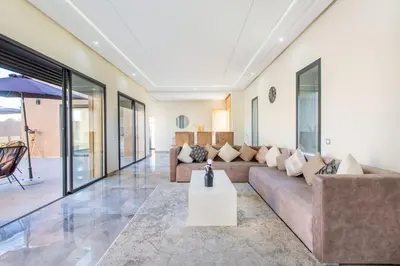 a living room with a couch and a table at Villa Kassia , Jacuzzi, Hamman, jeux… in Marrakech