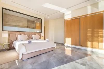 a bedroom with a large bed and a large window at Villa Kassia , Jacuzzi, Hamman, jeux… in Marrakech