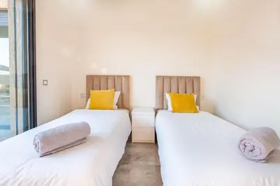 two beds in a room with white and yellow pillows at Villa Kassia , Jacuzzi, Hamman, jeux… in Marrakech