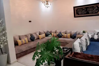 a living room with a brown couch with pillows at Appartement Azurite - Traditionnel & spacieux in Fès