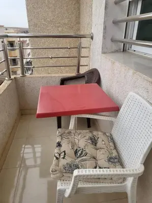 a red table and two chairs on a balcony at Appartement Azurite - Traditionnel & spacieux in Fès