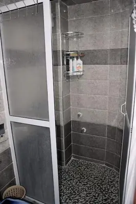 a shower with a glass door in a bathroom at Appartement Azurite - Traditionnel & spacieux in Fès