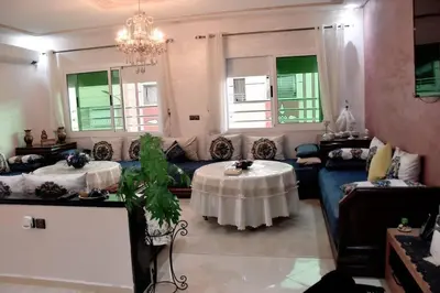 a living room with a table and a couch at Appartement Azurite - Traditionnel & spacieux in Fès