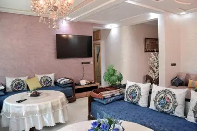 a living room with blue couches and a tv at Appartement Azurite - Traditionnel & spacieux in Fès